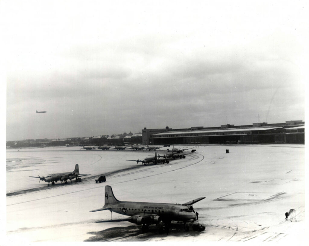 Vykládání transportních letadel C-54 na zasněženém letišti Tempelhof