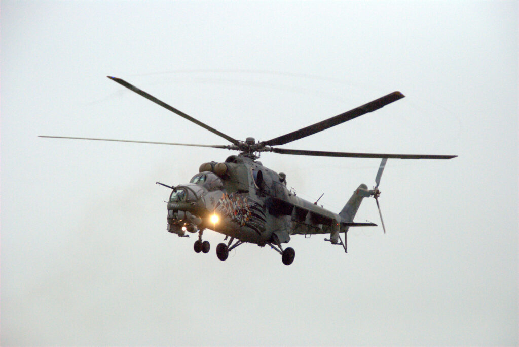 Český vrtulník Mi-24 Hind ve visu nad letištěm.
