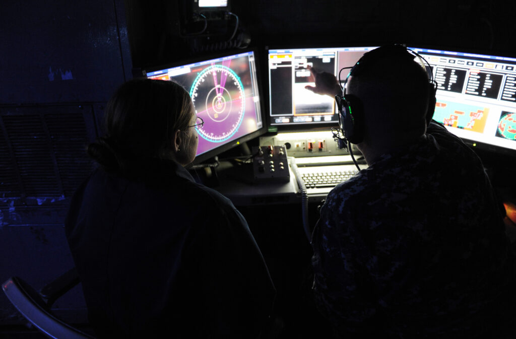 Dva členové posádky USS Ponce sledují monitory na řídicím stanovišti systému LaWS.