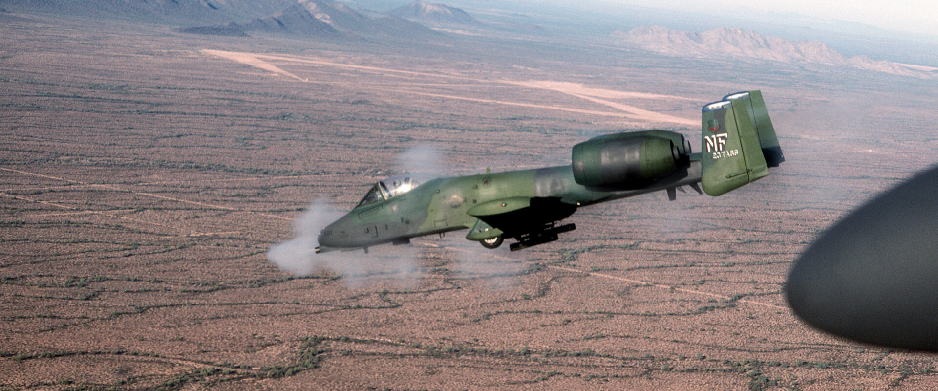 Bitevní letoun A-10 Thunderbolt II pálící ze sedmihlavňového rotačního kanónu za letu