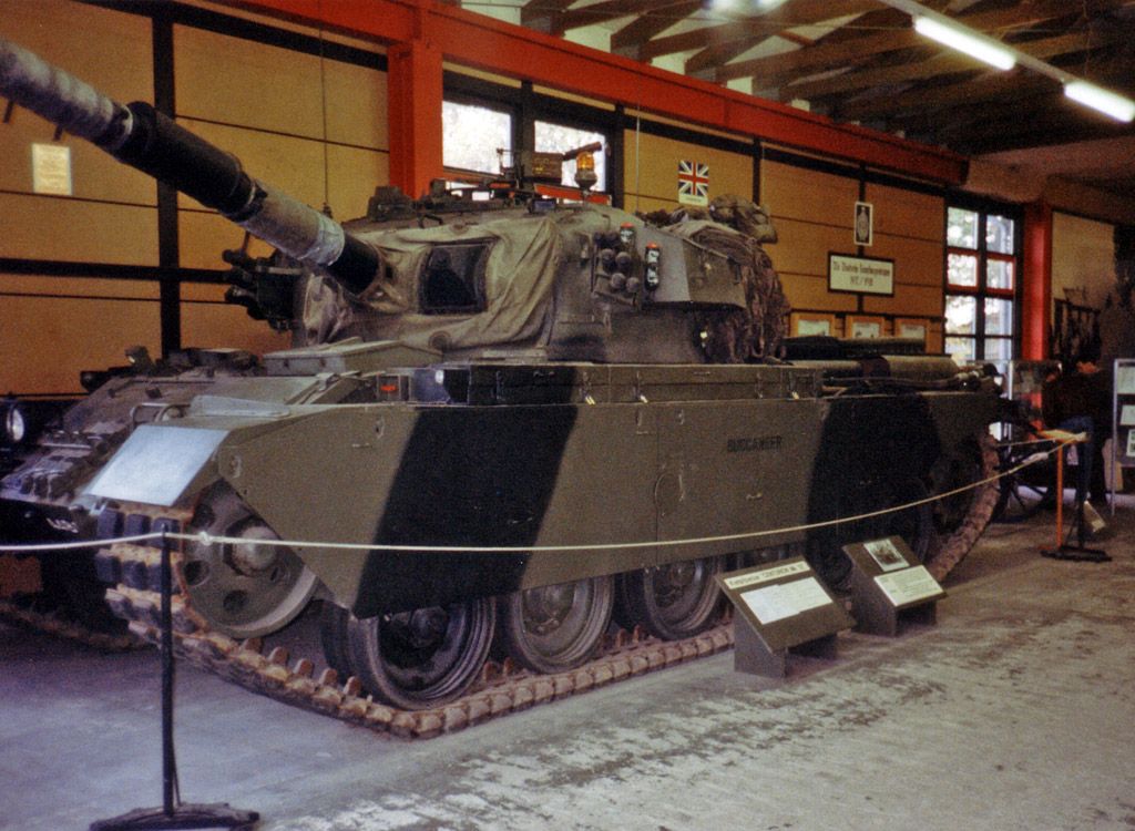 Centurion Mark 12 v muzejní hale, pohled zepředu a z boku na korbu, pásy a běžnou tankovou věž.