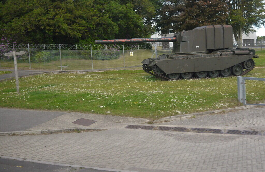 Britský FV4005 s vysokou hranatou věží a dlouhou hlavní na venkovním stanovišti v Bovingtonu.