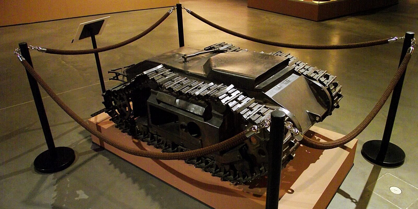 Tmavý Goliath Sd.Kfz. 303 vystavený za provazovou zábranou v Muzeu polské armády ve Varšavě.