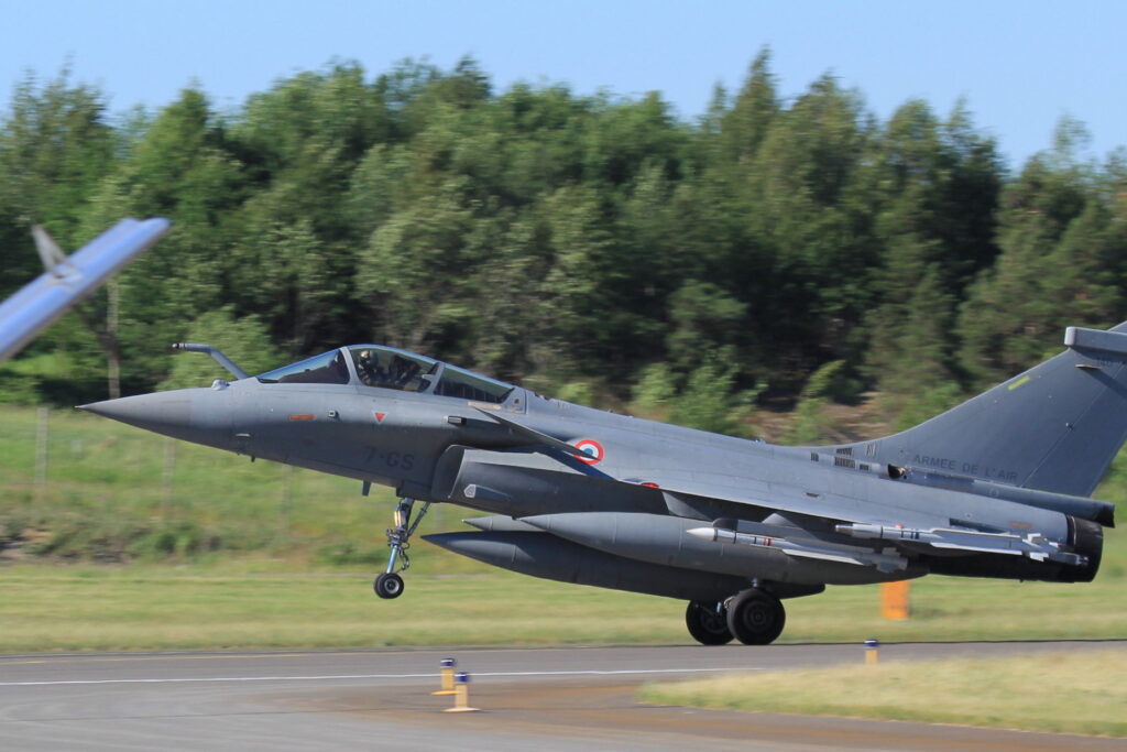 Francouzský Rafale s vysunutým podvozkem a vnějšími nádržemi nad dráhou.