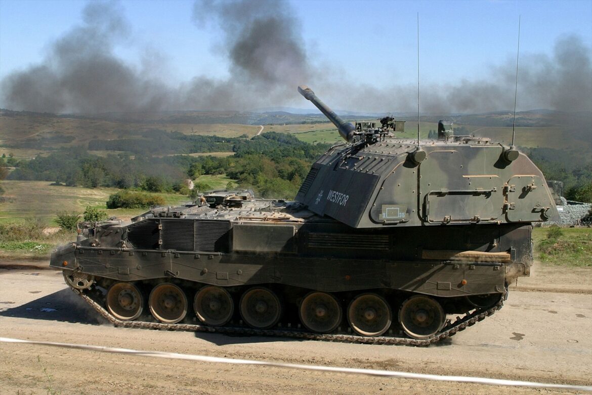 Německá samohybná houfnice Panzerhaubitze 2000 v palebném postavení při ostrém výstřelu s plamenem na ústí hlavně