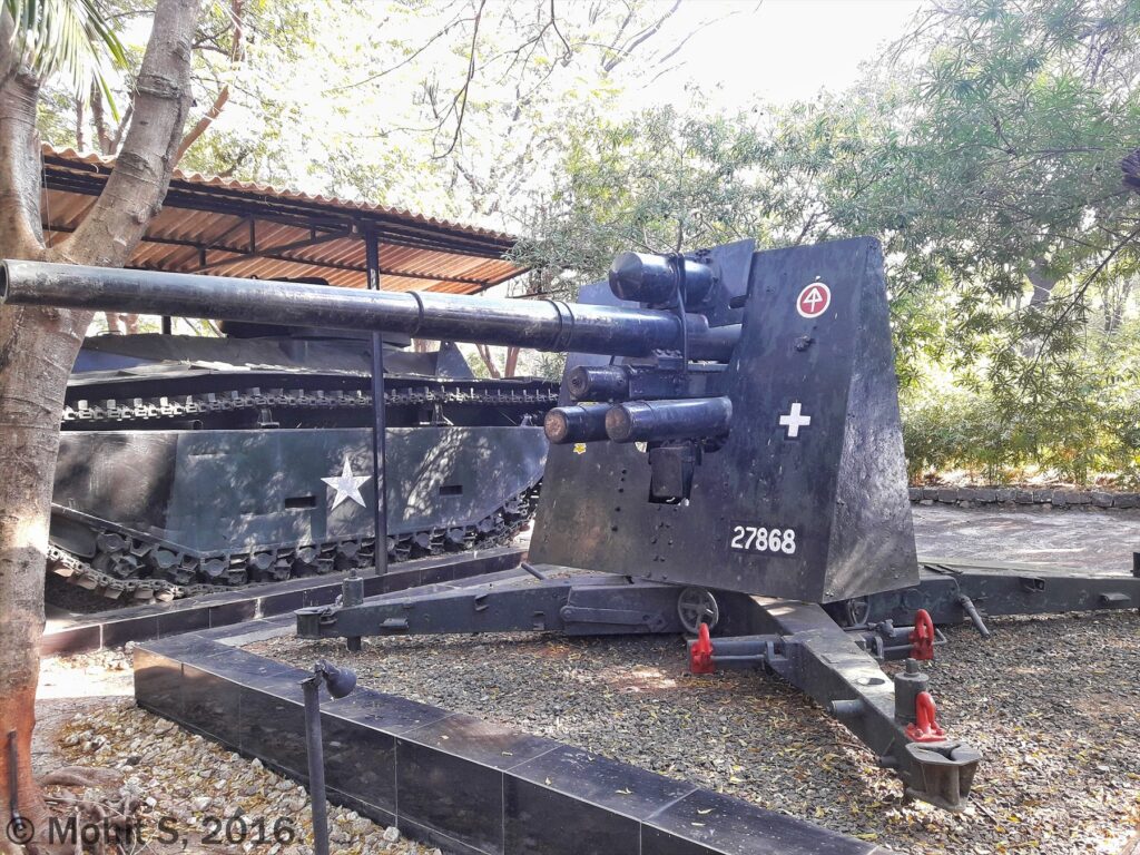 Černě natřený kanon Flak 37 s ochranným štítem v muzejní venkovní expozici.