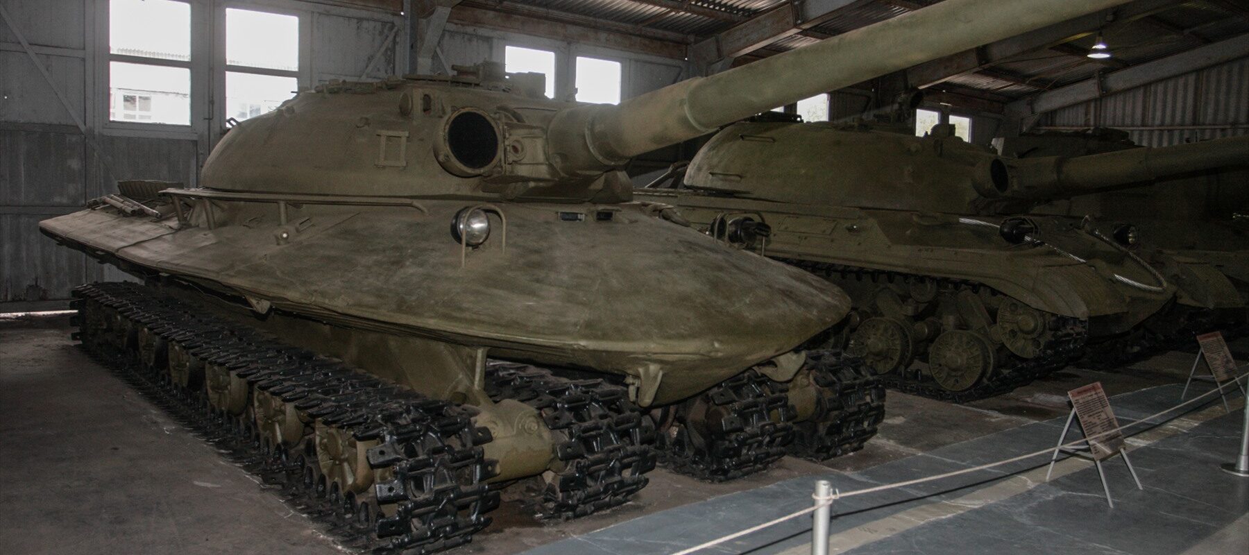 Čelní pohled na zaoblený sovětský tank Objekt 279 s dlouhým 130mm kanónem a čtyřmi pásy v muzeu