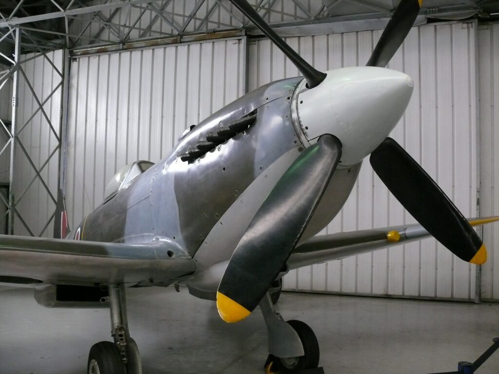 Pohled na trup a křídla historického stíhacího letounu Supermarine Spitfire v leteckém muzeu.