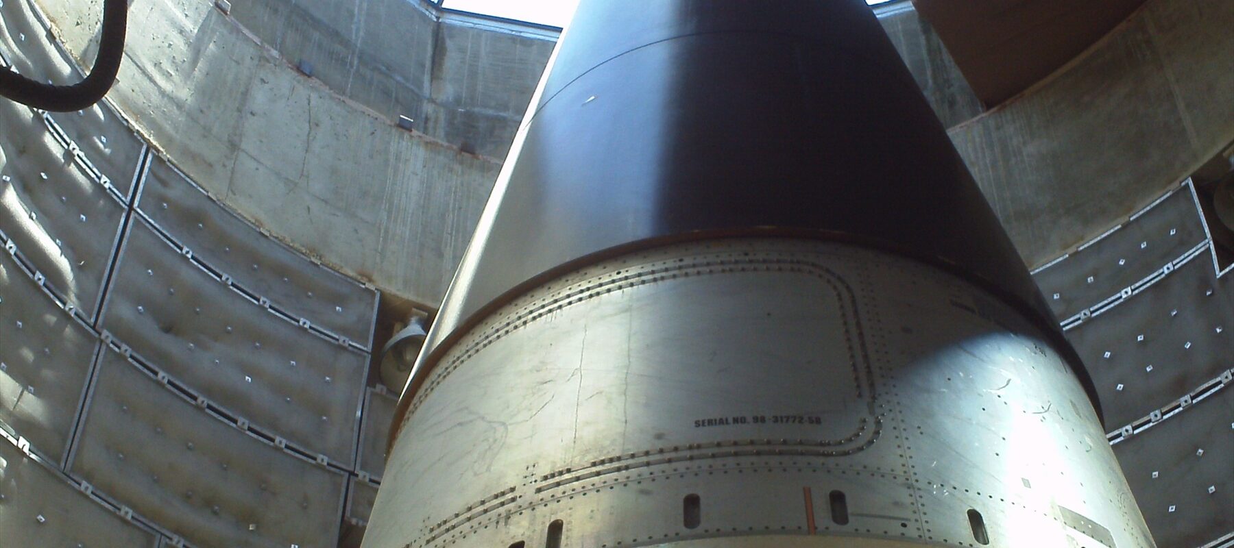 Horní část rakety Titan II uvnitř válcového sila s pootevřeným stropem