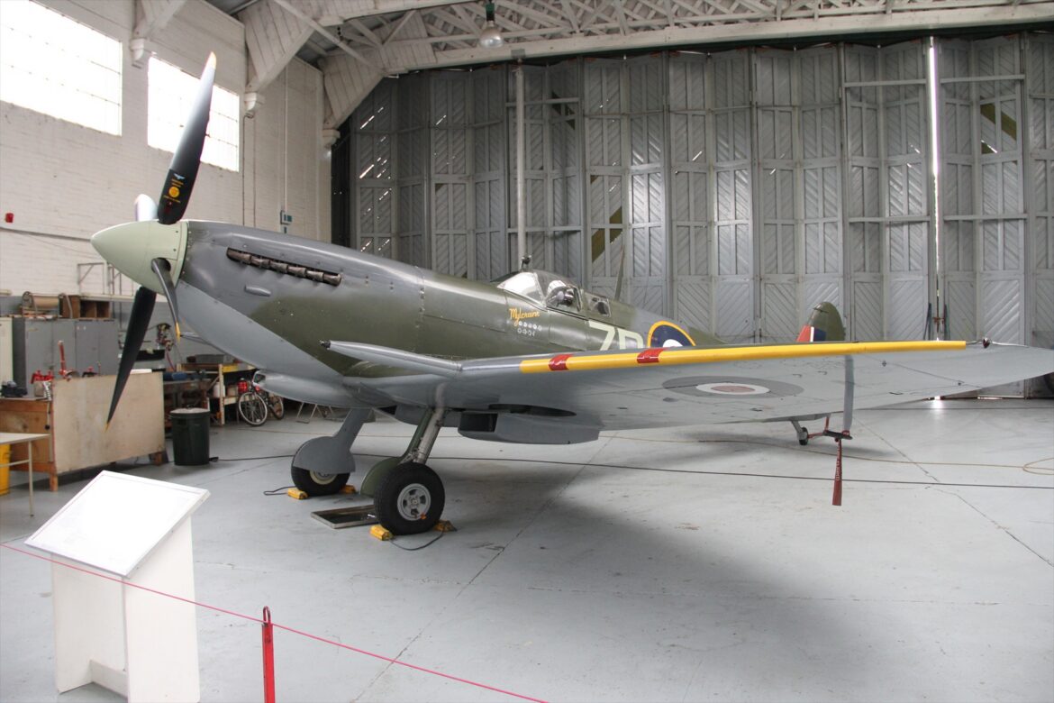 Britský stíhací letoun Supermarine Spitfire Mk IX zaparkovaný na zemi v leteckém muzeu v Duxfordu.