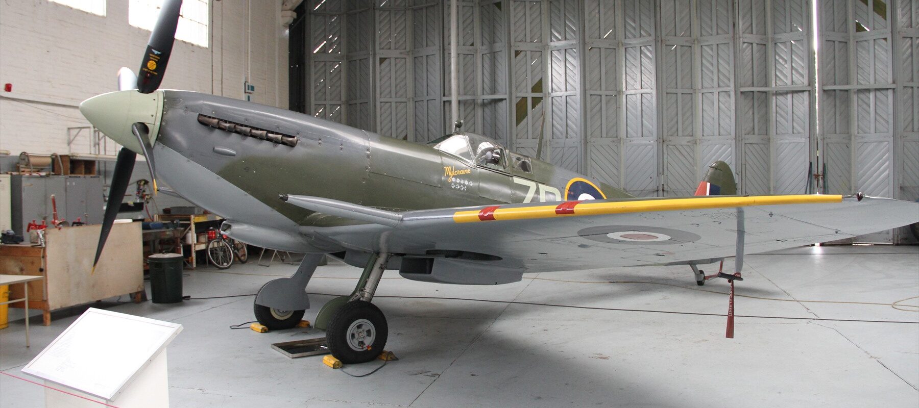 Britský stíhací letoun Supermarine Spitfire Mk IX zaparkovaný na zemi v leteckém muzeu v Duxfordu.