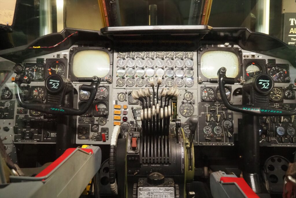 Pohled do pilotní kabiny bombardéru Boeing B-52H s analogovými přístroji a ovládacími prvky