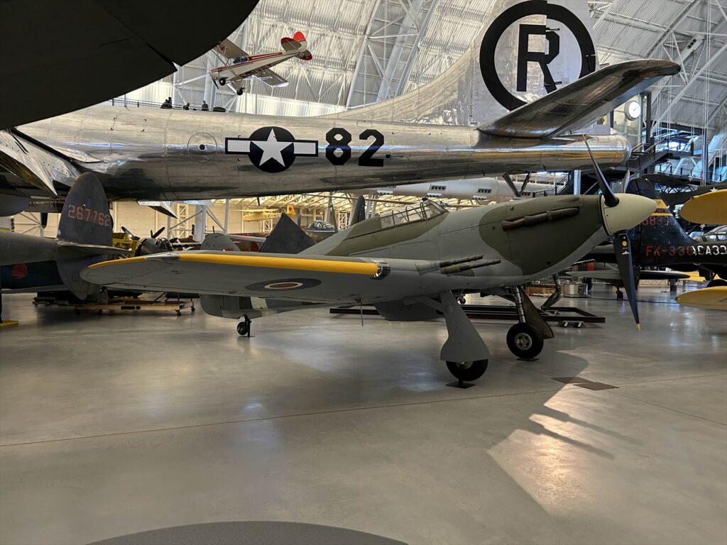 Pohled z boku na dochovaný stíhací letoun Hawker Hurricane Mk.IIc se čtyřmi křídelními kanony v muzejní expozici