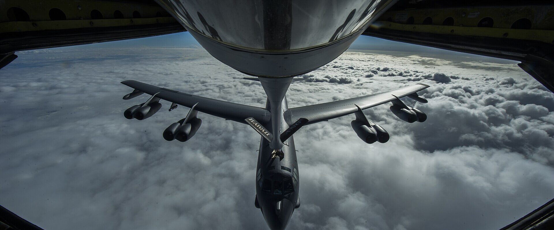 Bombardér B-52 Stratofortress při doplňování paliva za letu nad oblačností, pohled z tankovacího letounu