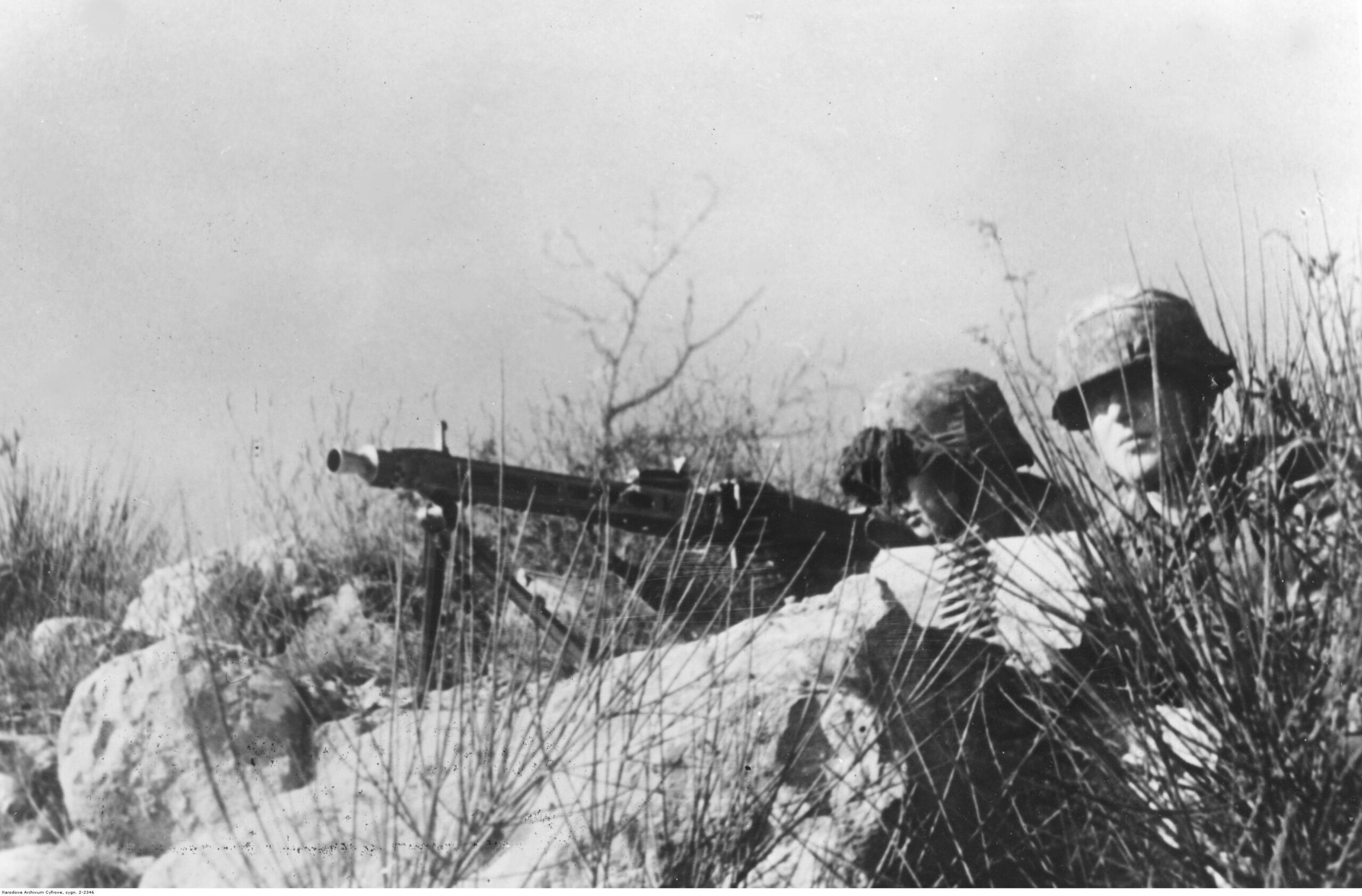 Němečtí kulometčíci pálící z kulometu MG 42 upevněného na těžké trojnožce