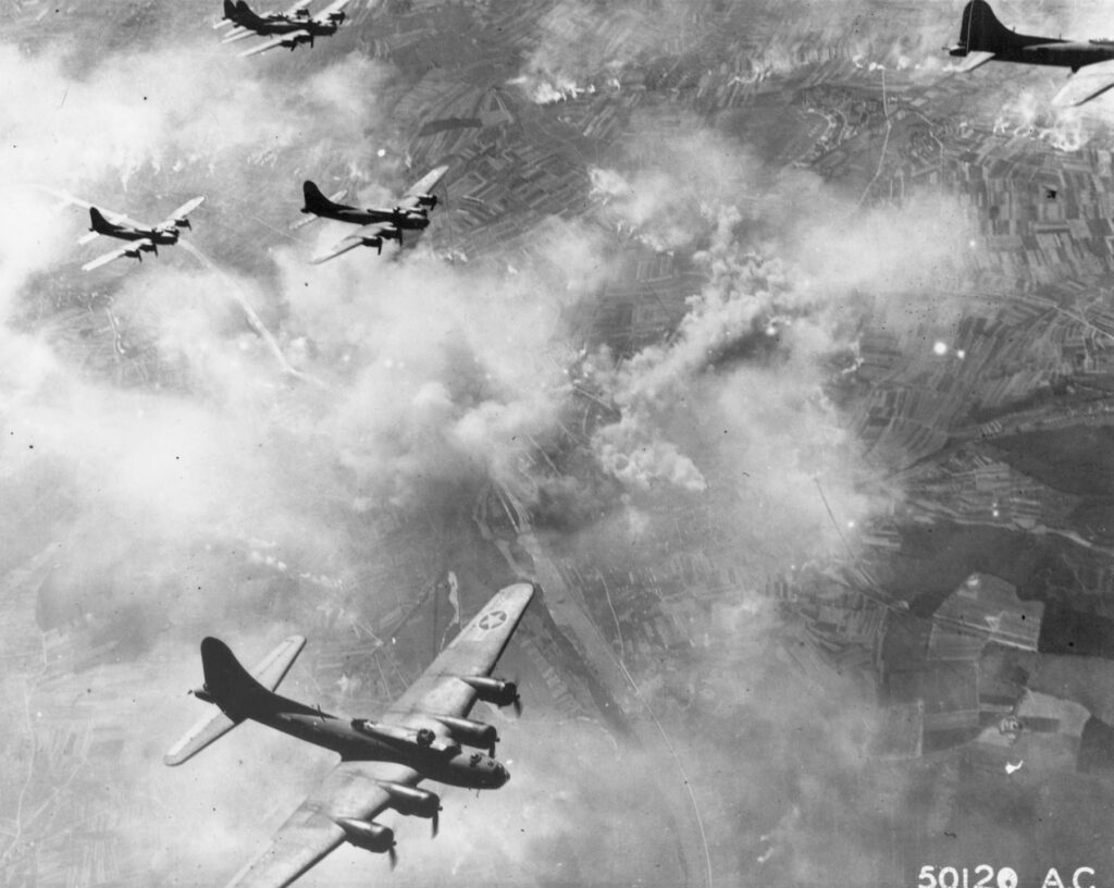 Sevřená formace bombardérů B-17 nad Schweinfurtem v Německu s kouřem a kondenzačními stopami, srpen 1943