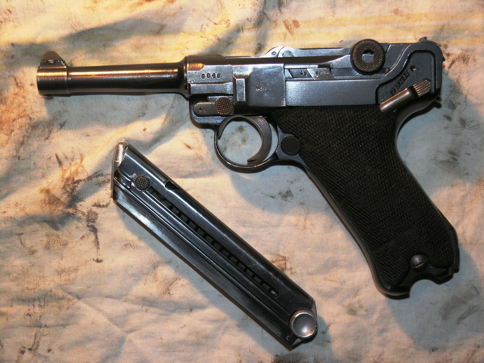 Boční profil německé armádní pistole Luger P.08 se záchytem zásobníku a štíhlou hlavní