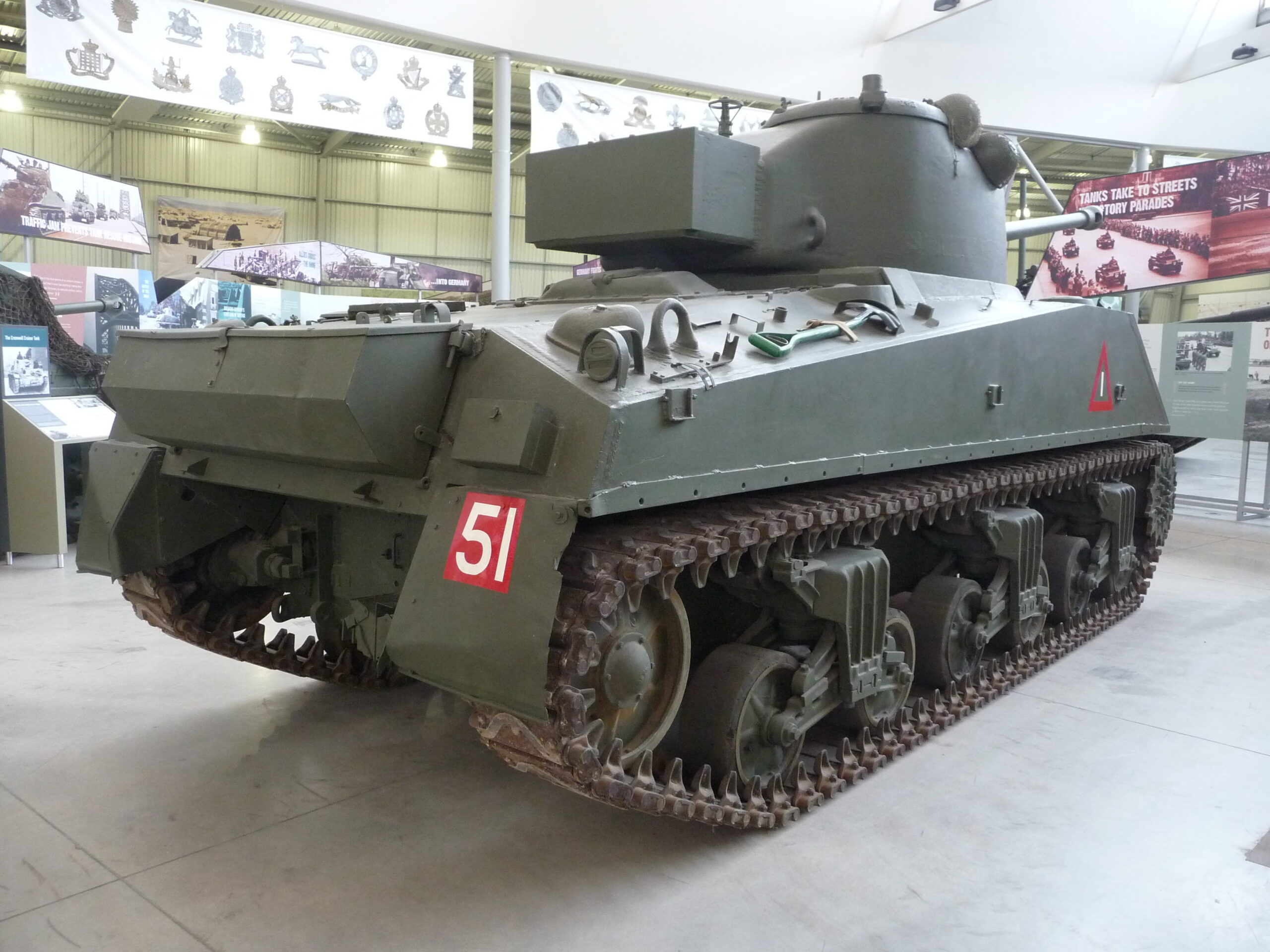 Boční pohled na věž tanku Sherman Firefly s dlouhou hlavní kanonu a přídavnou pancéřovou schránkou