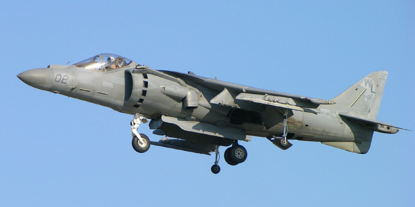 Bojový letoun AV-8B Harrier II ve visu ve vzduchu s otočnými tryskami směřujícími k zemi