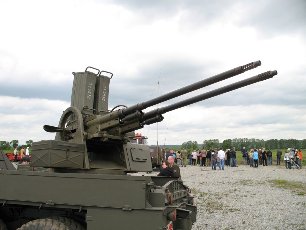 Detailní pohled na dvojici hlavní 30mm kanónů vz. 53 a shora nasazené zakřivené schránkové zásobníky na padesát nábojů.