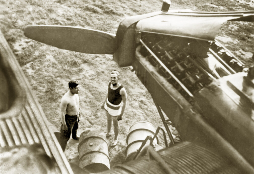 Historický čtyřmotorový těžký bombardér Tupolev TB-3 s vlnitým duralovým potahem stojící na letištní ploše.
