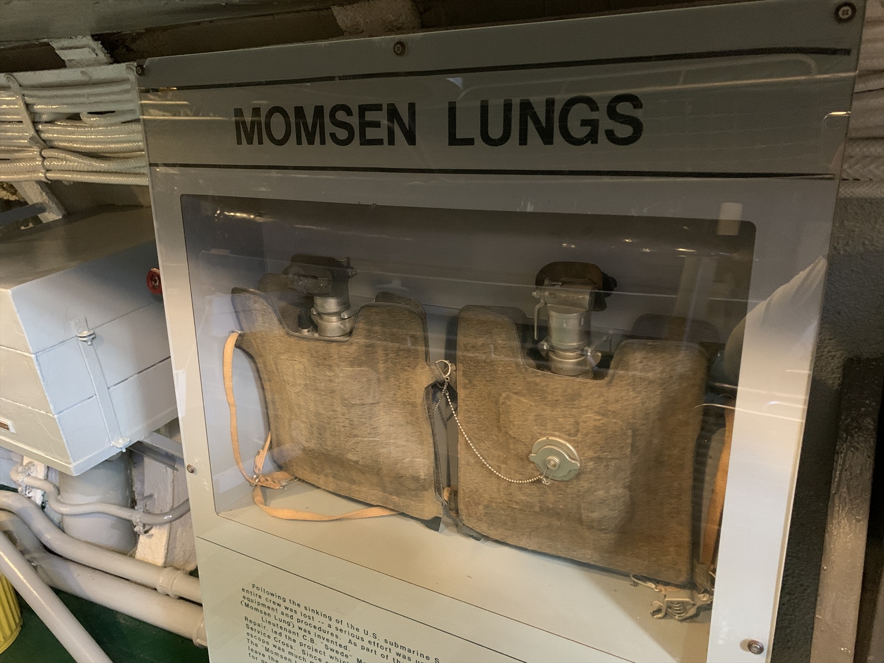 Dva záchranné dýchací přístroje pod nápisem Momsen Lungs ve vitríně na USS Drum.