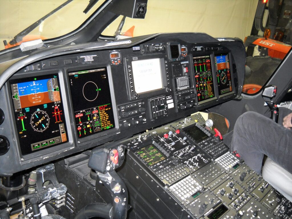Pohled do kokpitu vrtulníku AW139 s rozsvícenými multifunkčními displeji skleněného kokpitu
