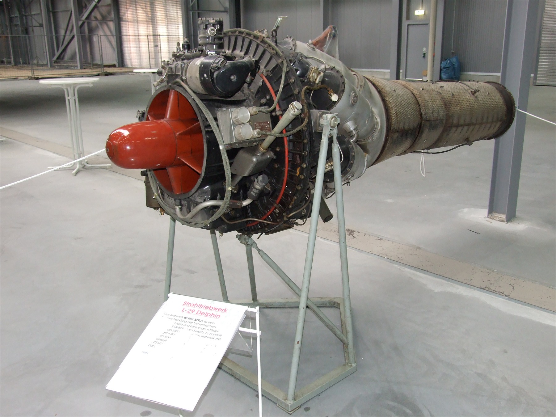 Samostatně vystavený proudový motor M-701 na podstavci v muzejní expozici.