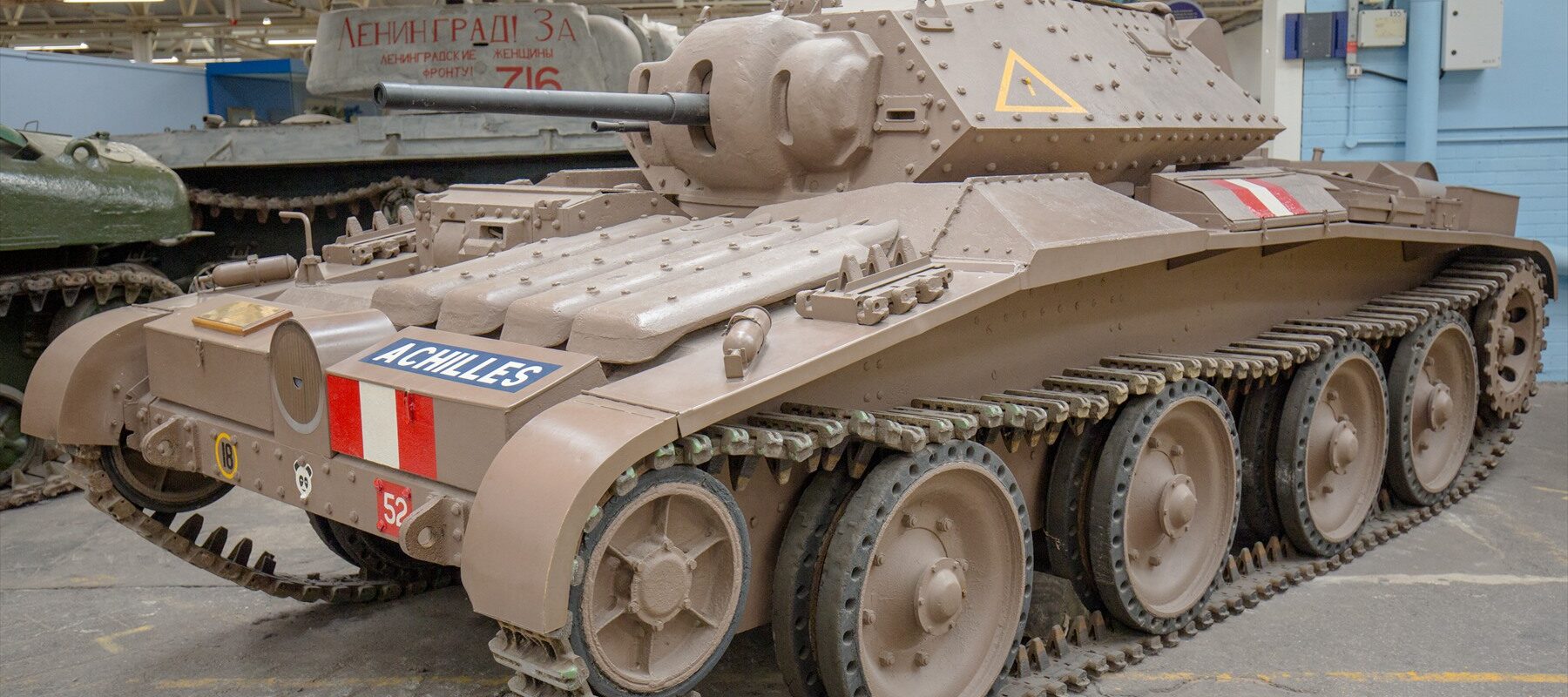 Tank Covenanter s nápisem Achilles v muzejní hale, pohled zepředu zleva.