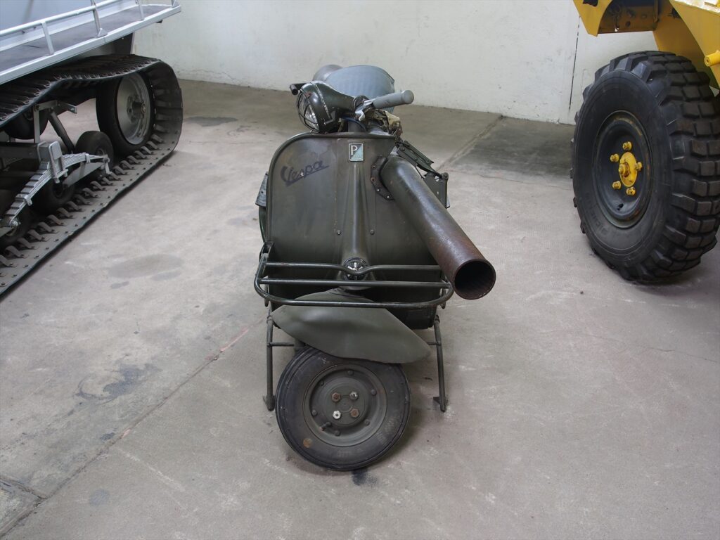 Boční pohled na vojenský skútr Vespa 150 TAP v khaki barvě se zabudovaným 75mm bezzákluzovým kanónem pod sedadlem.