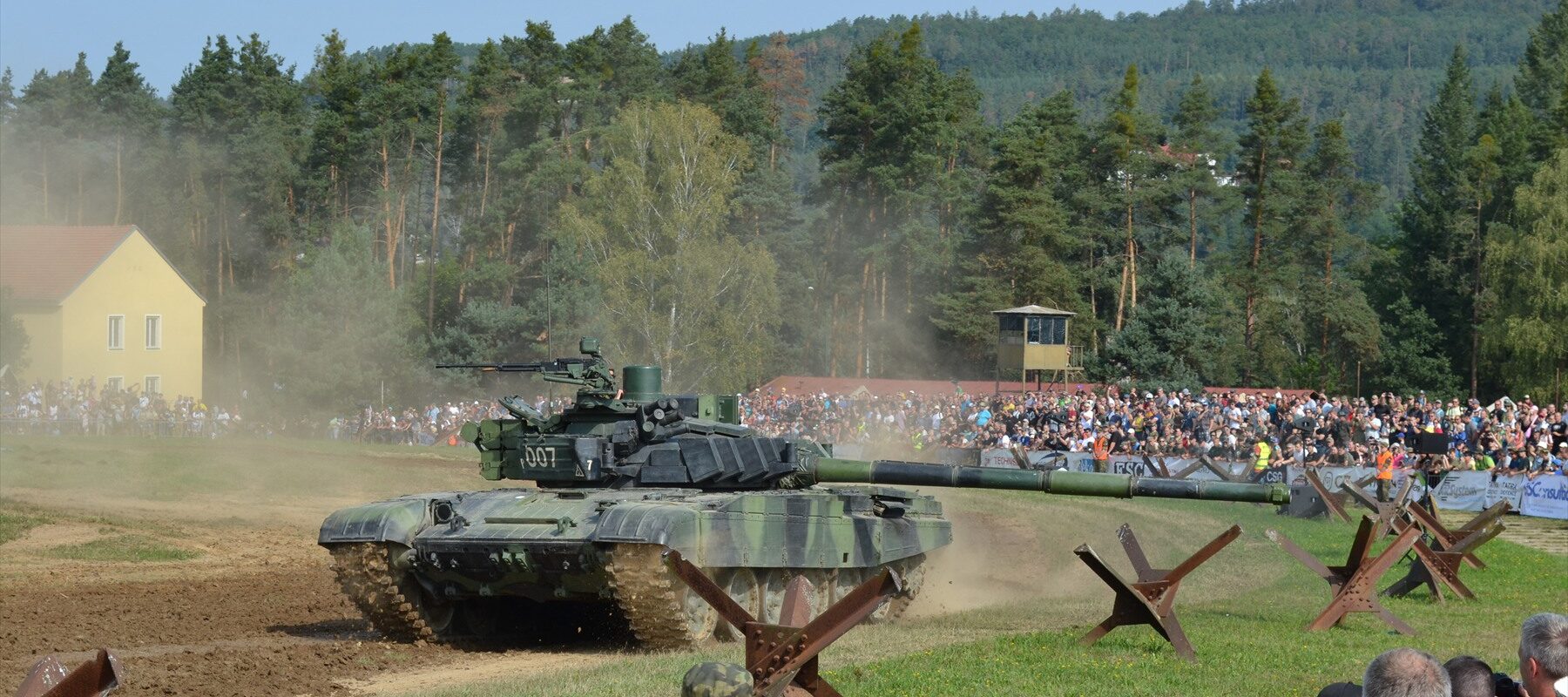 Český modernizovaný tank T-72M4 CZ s dynamickým pancířem projíždí terénem před diváky