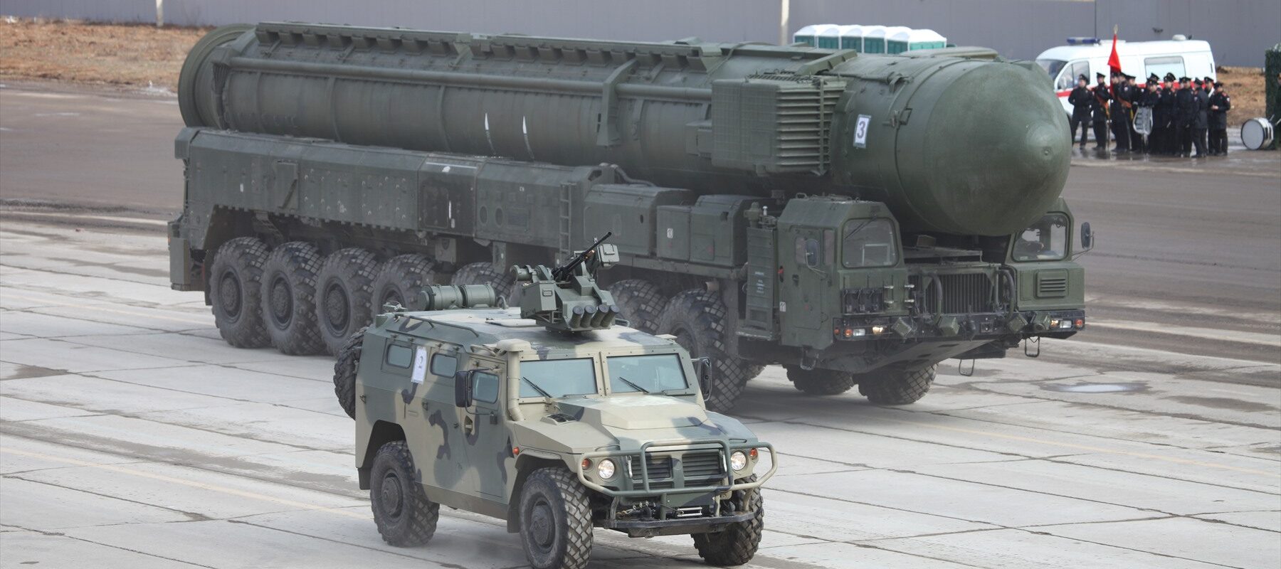 Vozidlo Tigr-M před velkým kolovým nosičem rakety RS-24 Jars.
