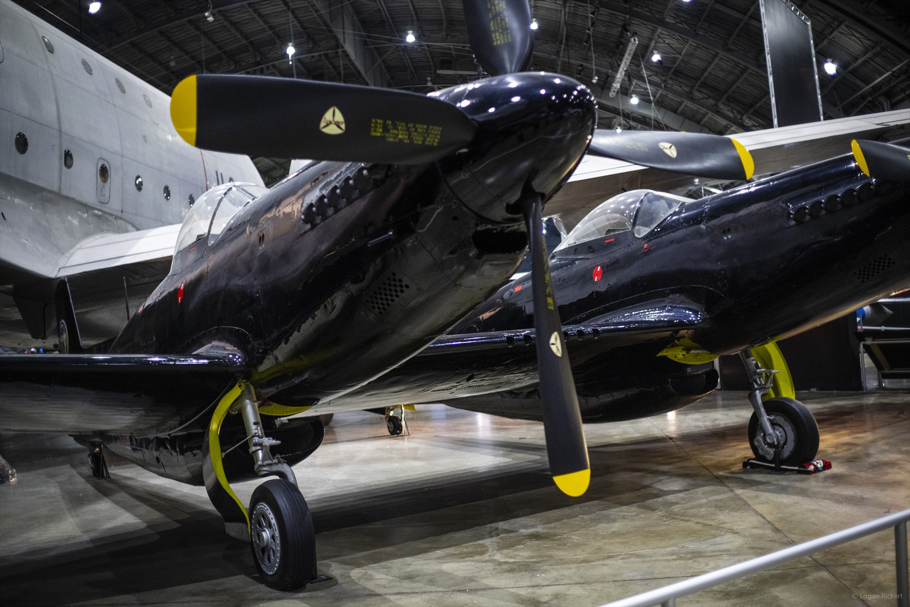 Černý dvoutrupý Twin Mustang s radarovou gondolou mezi trupy v muzeu USAF.