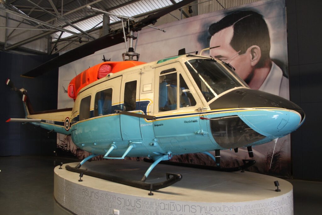 Vojenský vrtulník Bell UH-1N Twin Huey v šedé kamufláži na pojezdové ploše letiště