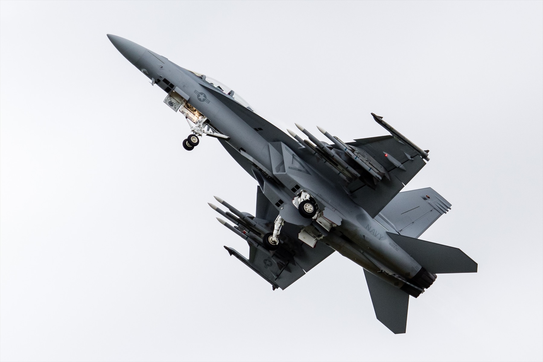 F/A-18F Super Hornet ve stoupání s vysunutým podvozkem a podvěsy při pohledu zespodu