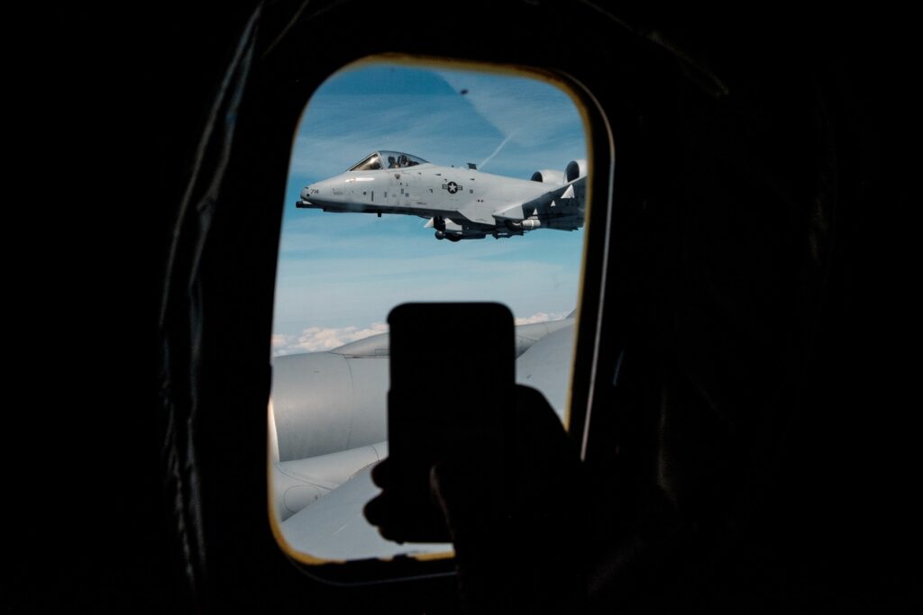 Pohled zepředu na bitevní letoun A-10 Thunderbolt II s dvěma proudovými motory nad trupem během doplňování paliva za letu