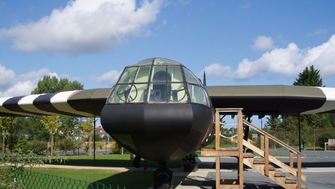 Celodřevěný britský transportní kluzák Airspeed Horsa s invazními pruhy vystavený v areálu památníku Memorial Pegasus v Bénouville