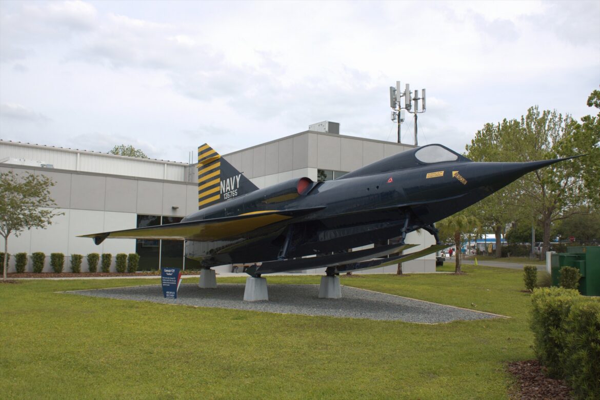 Tmavomodrý Sea Dart s vysunutými lyžemi před budovou Florida Air Museum