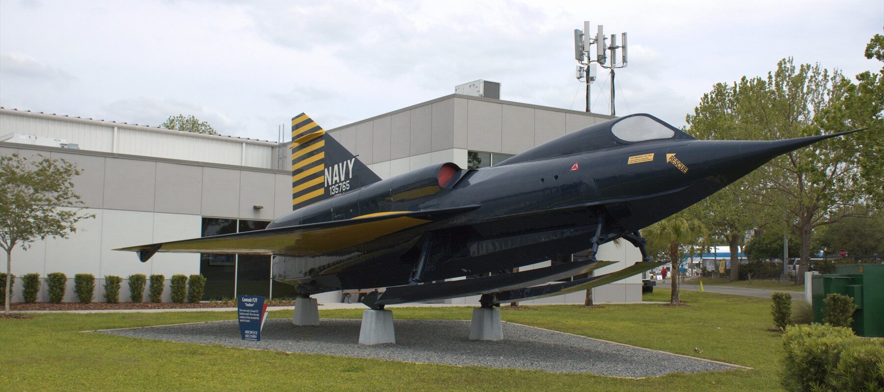 Tmavomodrý Sea Dart s vysunutými lyžemi před budovou Florida Air Museum
