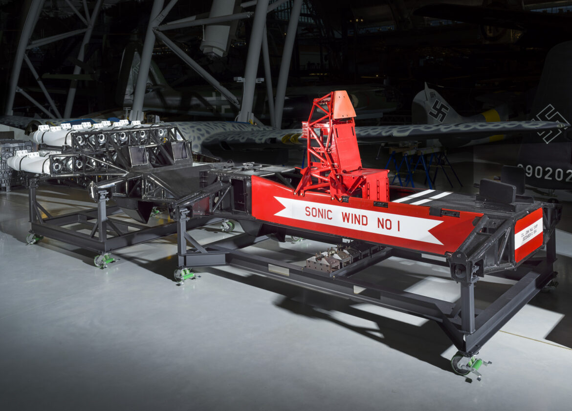 Červené a černé saně Sonic Wind I s otevřeným sedadlem a raketovými motory v muzejní hale