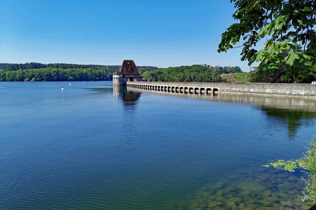 Pohled na kamennou korunu a oblouky mohutné gravitační hráze přehrady Möhnesee
