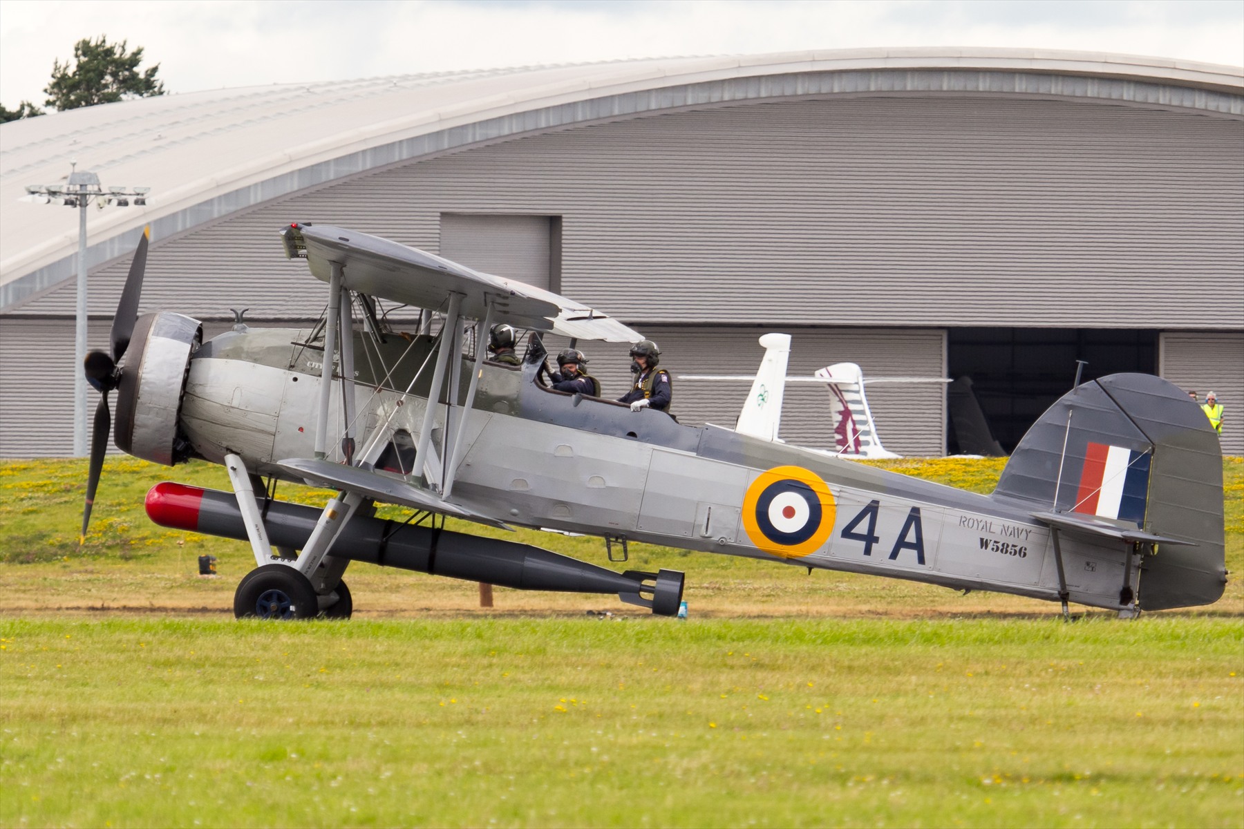 Swordfish W5856 na trávě s členy posádky v otevřených kabinách.