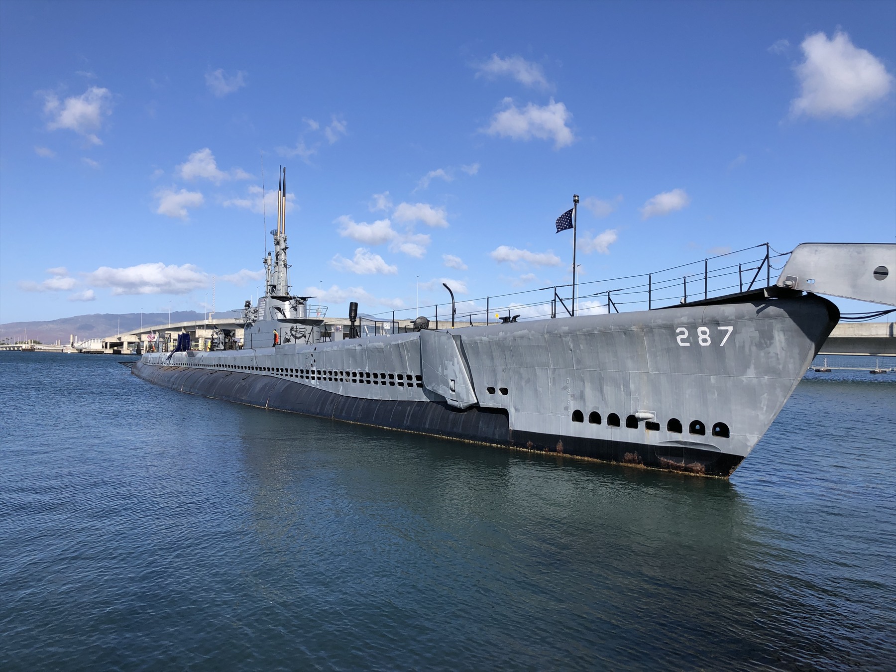 Šedá ponorka USS Bowfin s číslem 287 na přídi kotví v Pearl Harboru.