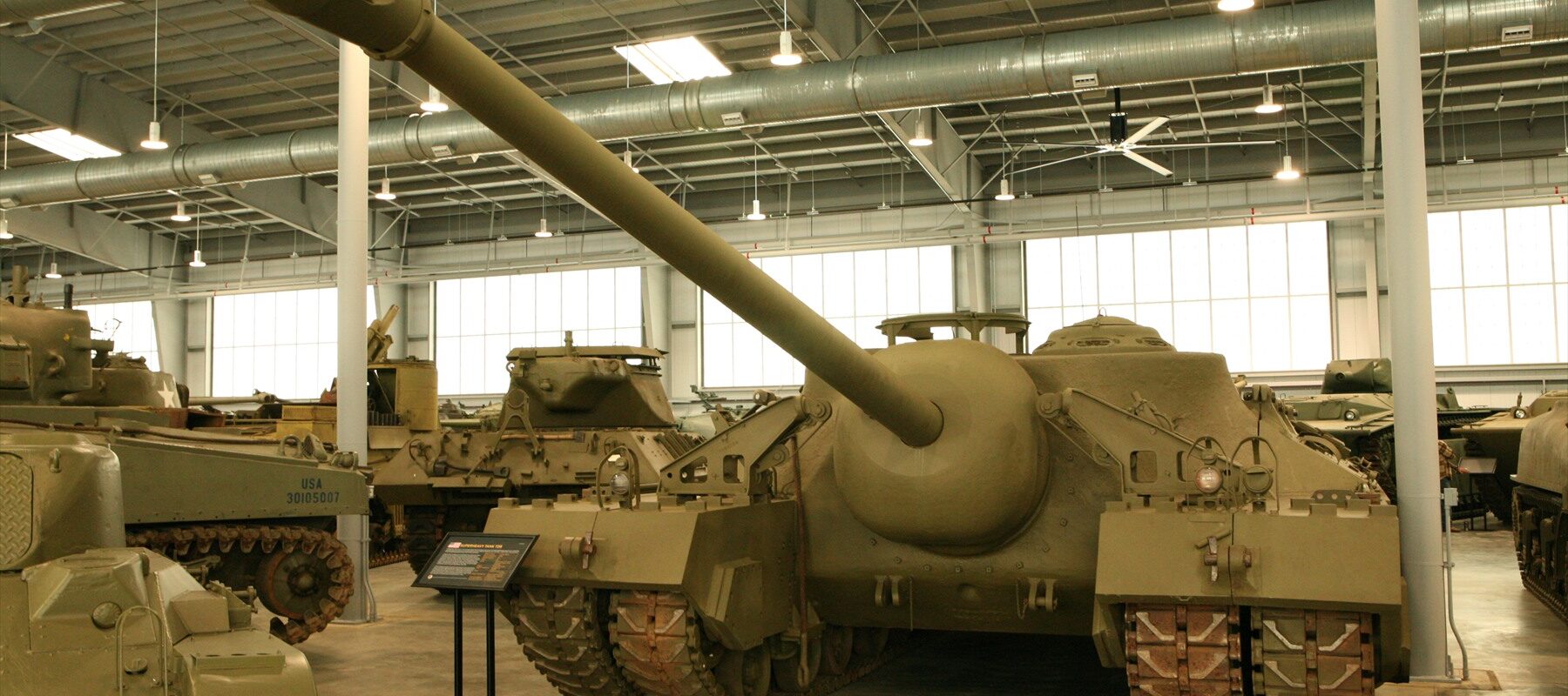 Celkový boční a čelní pohled na masivní americký supertěžký tank T28 se čtyřmi pásy a dlouhým kanónem