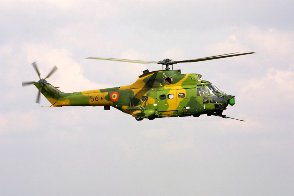 Rumunský vojenský vrtulník IAR-330 Puma SOCAT v kamufláži s podvěsnou výzbrojí a elektrooptickým pouzdrem v přídi