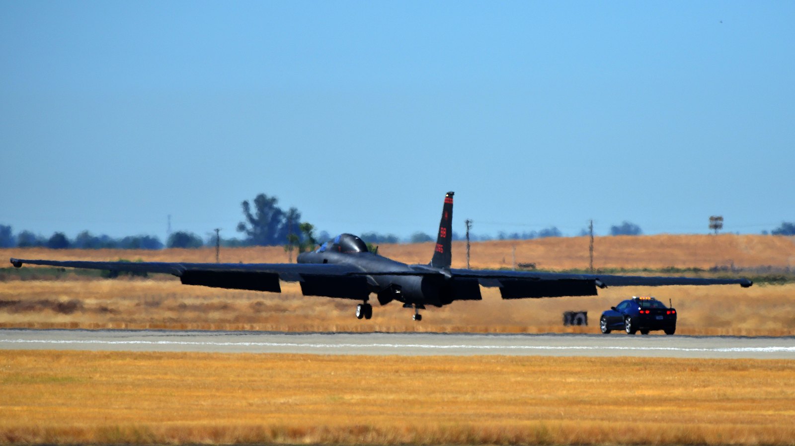 Rychlé doprovodné vozidlo chase car sleduje přistávající letoun Lockheed U-2 na ranveji základny Beale