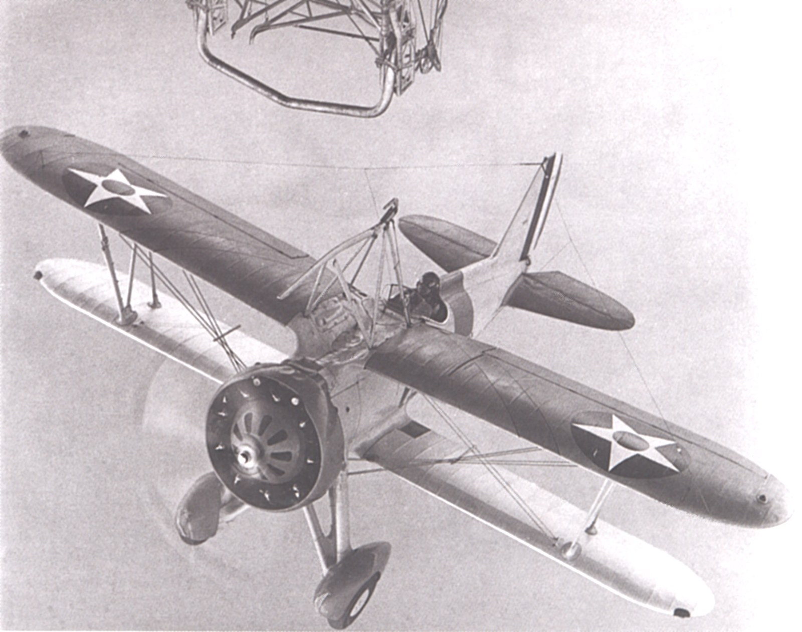Stíhací dvouplošník Curtiss F9C Sparrowhawk se přibližuje k záchytné hrazdě vzducholodi.