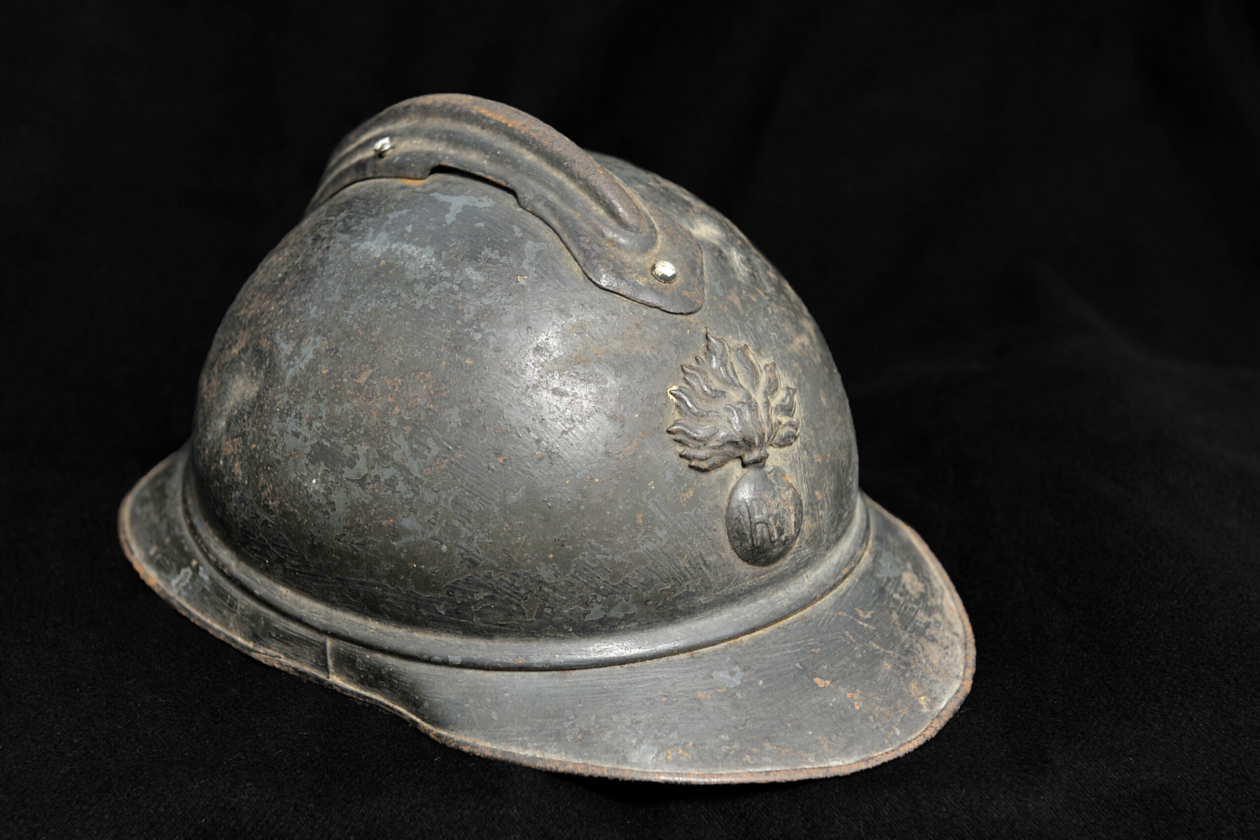 Francouzská ocelová přilba Adrian vzor 1915 s reliéfním hřebenem a odznakem hořícího granátu