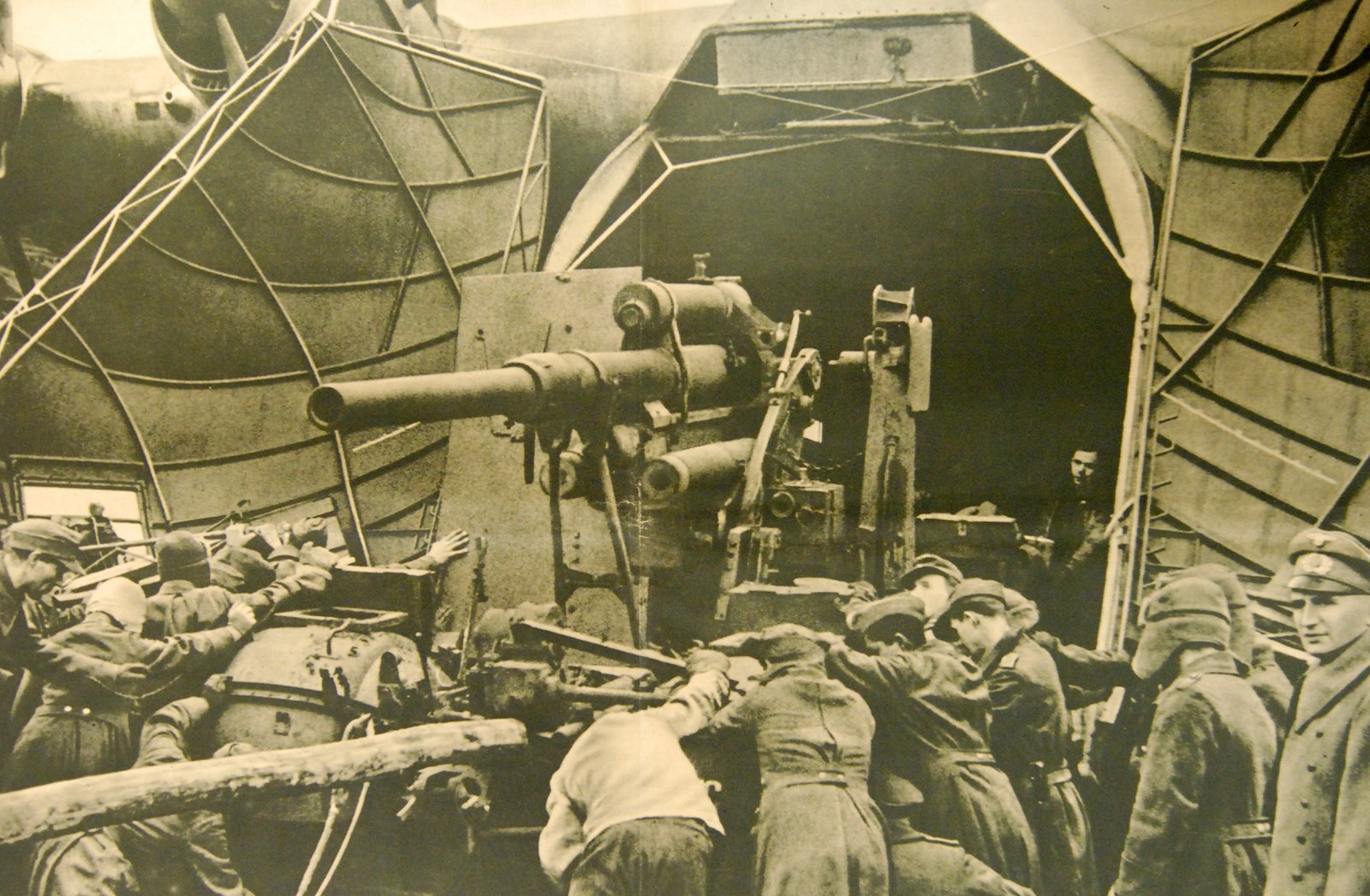 Němečtí vojáci nakládají těžké tažené dělo otevřenými příďovými vraty do nákladového prostoru letounu Messerschmitt Me 323.