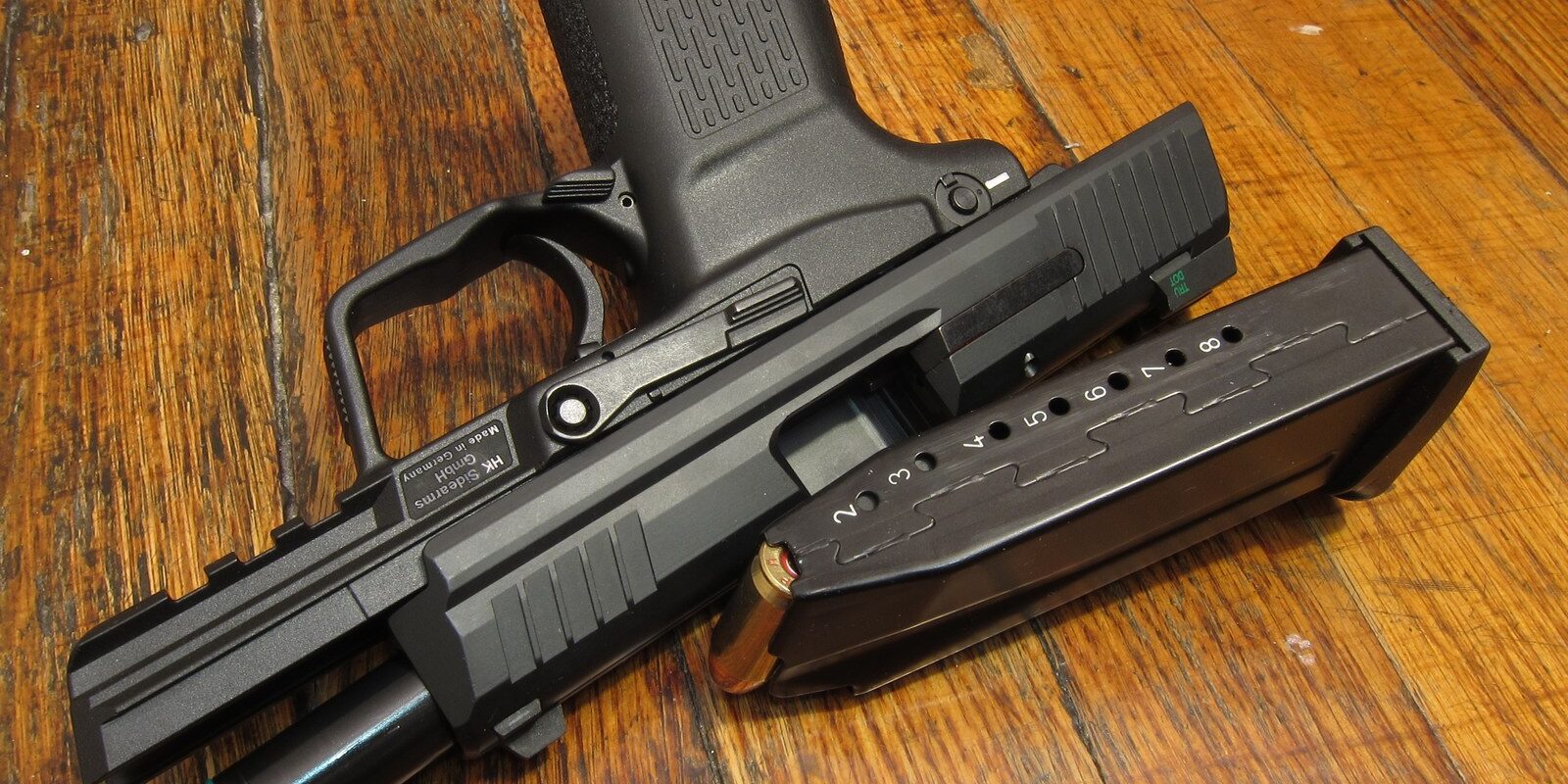 Poloautomatická pistole Heckler & Koch HK45 ráže čtyřicet pět položená na stole.